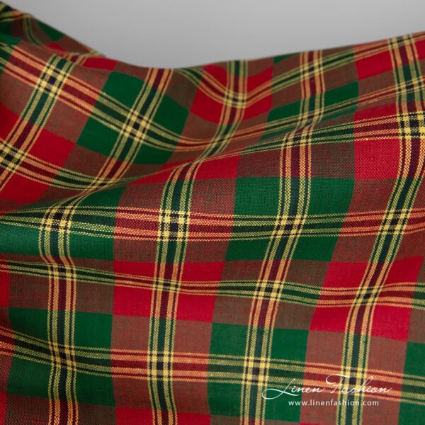 Linen / cotton fabric features a pattern consisting of criss-crossed horizontal and vertical bands of red, green and yellow colours