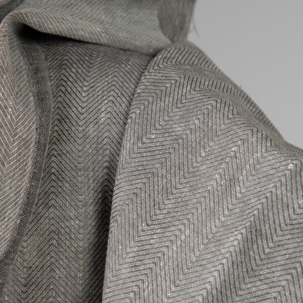 Linen fabric greyish brown in herringbone pattern close up detail