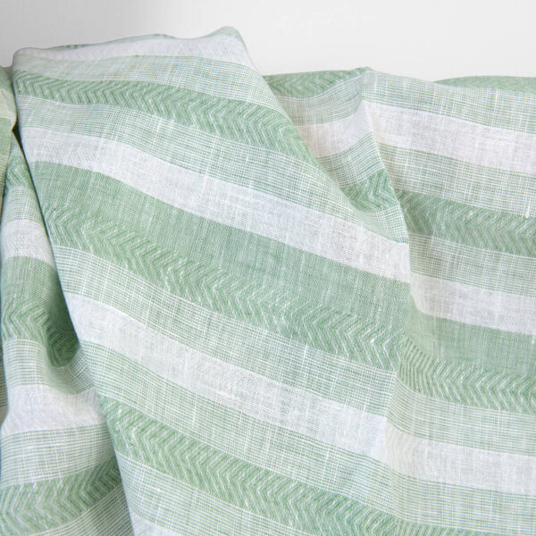Linen fabric in pale green and white herringbone stripes, unwashed